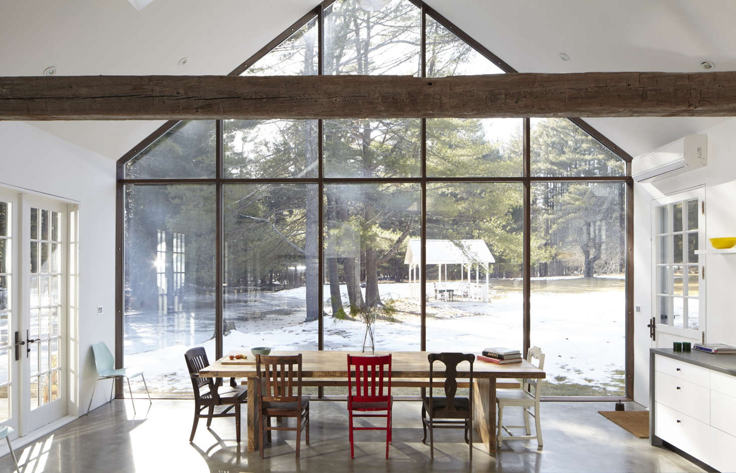 The kitchen resides in a modern addition that echoes the roofline of the original house. The 22-foot-high glazed curtain wall is skyscraper glass in a steel framework; it overlooks a brook and a gazebo.