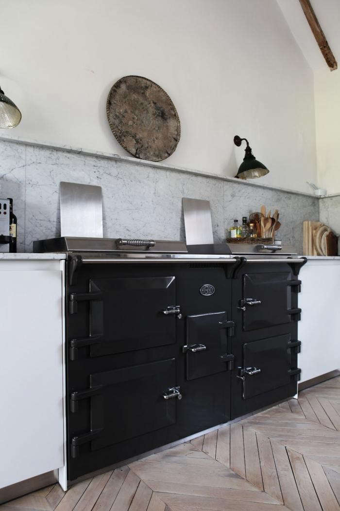 The Everhot 150i features three independently controllable ovens, two cast-iron plates, and a three-zone induction hub. Go to Cast-Iron Range Cookers for sourcing in the UK.