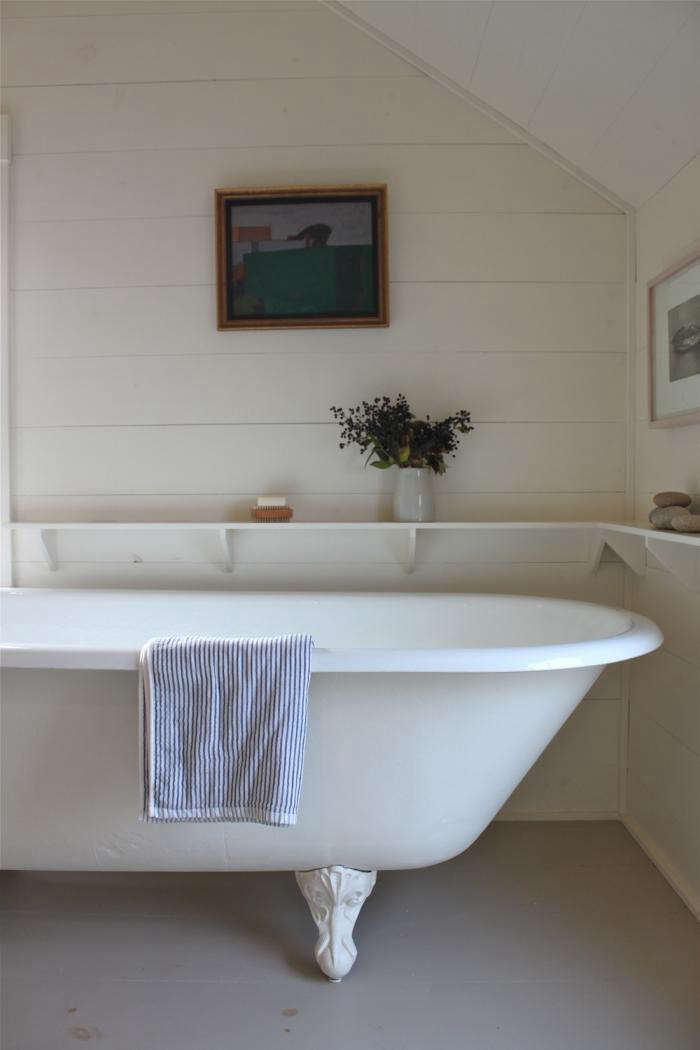 A Cottage Reborn in Coastal Maine has hardwearing bathroom floors in a light gray.