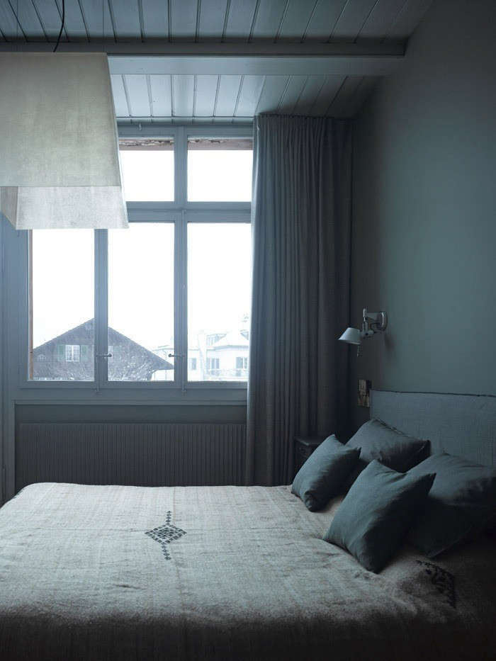 A serene bedroom in a 0-year-old chalet remodeled by Zurich