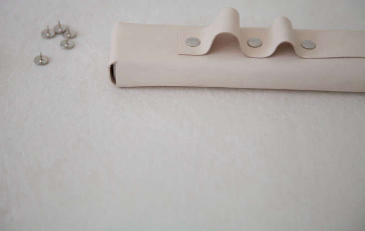 Step 5: Push the leather against itself until it makes a loop. Secure the loop in place with a pushpin, and then continue making loops and pinning them down, adjusting each to your liking, until you’re an inch from the end.