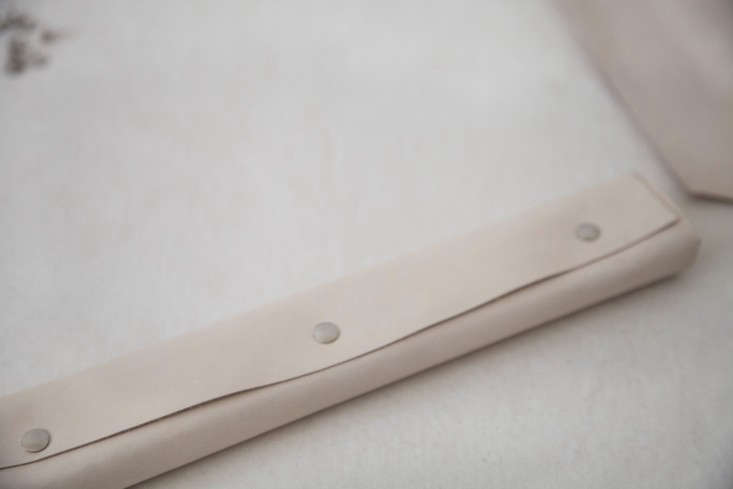 Step 3: Once you’ve pinned down each end of the wood, fully wrap the block overlapping the leather on the side that won’t show (and trimming as necessary). Secure the leather in place with a series of evenly spaced pushpins (I used three).