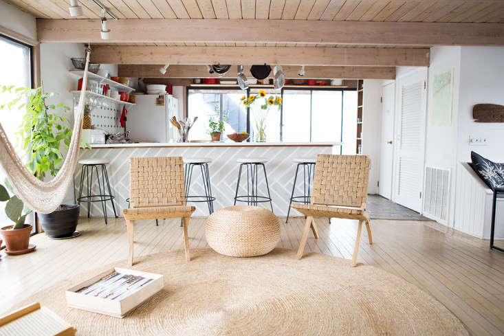 The room opens onto the kitchen sectioned off by a bar. The rope chairs are from Urban Outfitters.