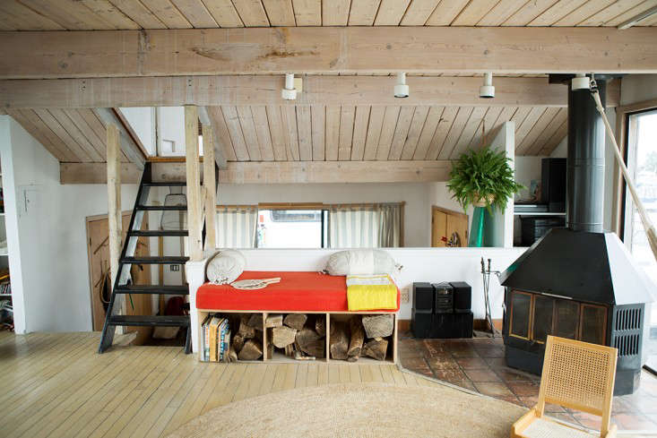 A built-in daybed (with firewood storage) and a woodstove in the living room.
