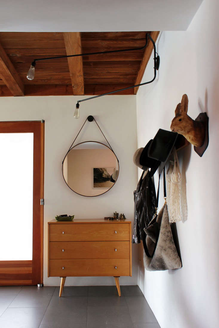 A BDDW Captain’s Mirror sits above a vintage Paul McCobb dresser. Carla had a hat rack made with spacing far enough apart for wide brims. The papier-mí¢ché hare is a recent addition picked up at the Nickey Kehoe Shop.
