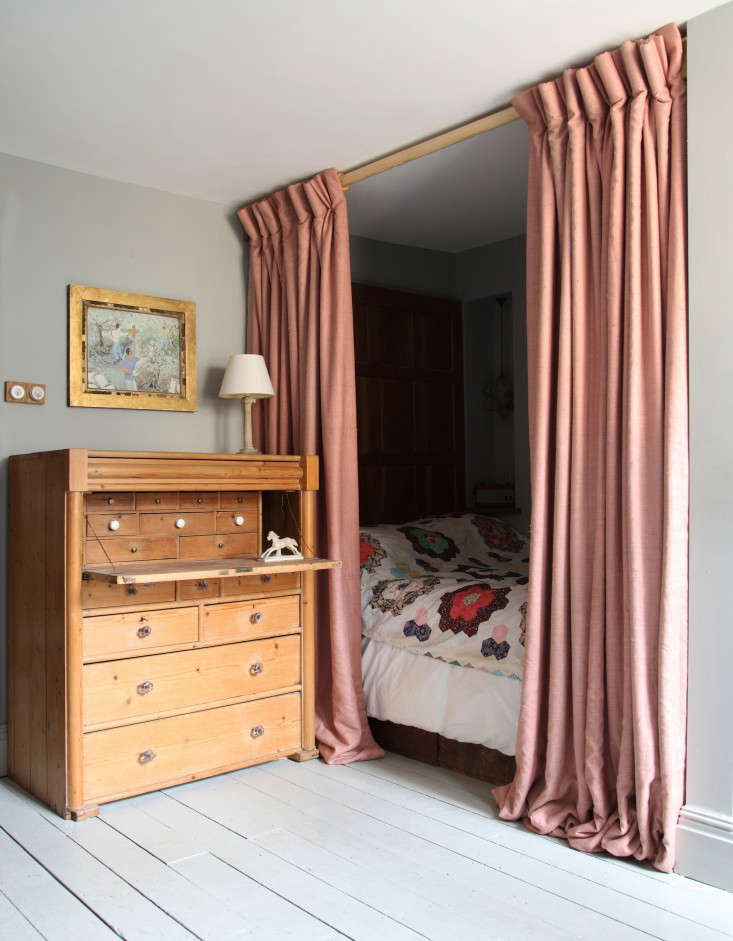 Shut out the light (and create a sleep cocoon) with a curtained bed. Photograph from Out with the New: Reinventing the Past in a London Remodel.