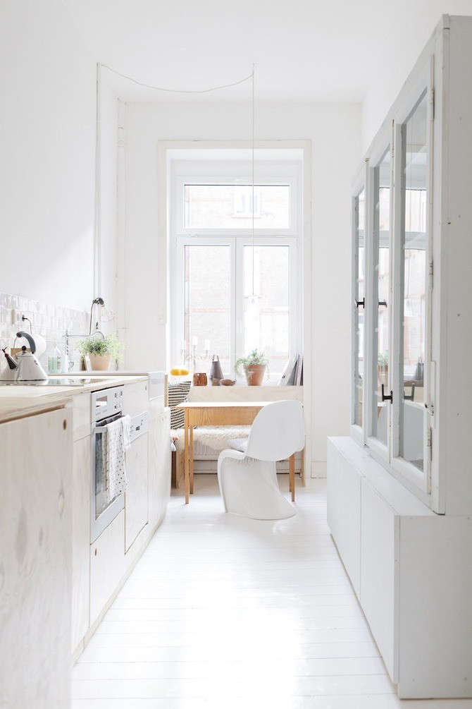 Plywood cabinets with cutout cabinet pulls in a bright German kitchen. (Note also the built-in plywood bench in the small breakfast area.) See Happiness at Home with a German Design Duo.