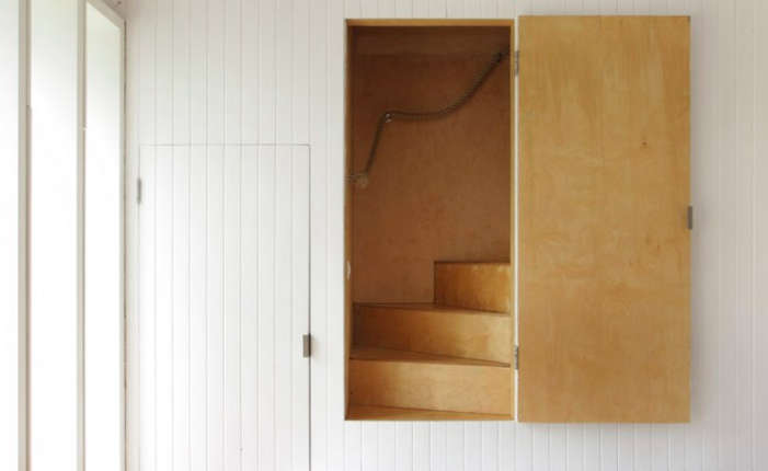 A concealed plywood staircase leads to a loft in The Brick Barn: A Modern English Farmhouse in Norfolk.