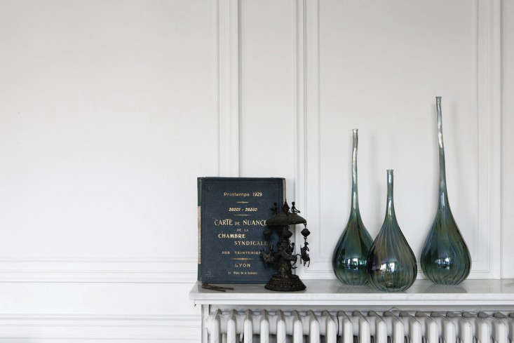 Top radiators with thin marble pieces to create an instant sideboard or place for display, as seen in An Artfully Appointed Parisian Flat.