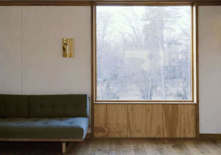 Plywood frames a window in a bare-bones summerhouse. See Scandinavian Simplicity: A Reimagined Swedish Summerhouse.