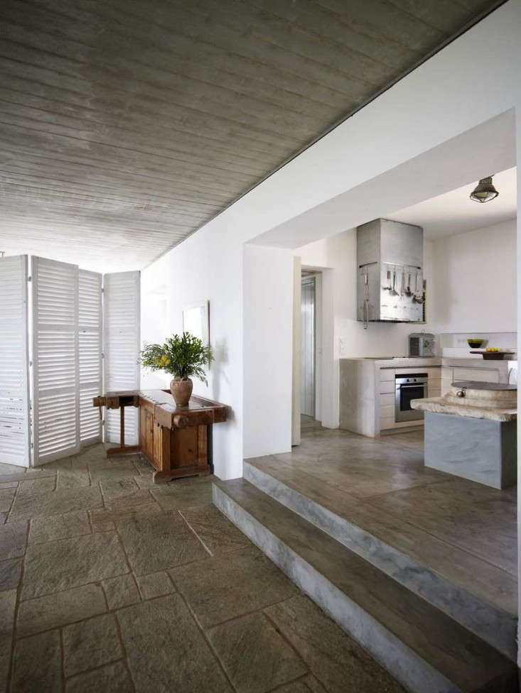 The kitchen steps down to the dining area and living room. The floor is made of stone from Pelion, “a building material often used in Hydra.”
