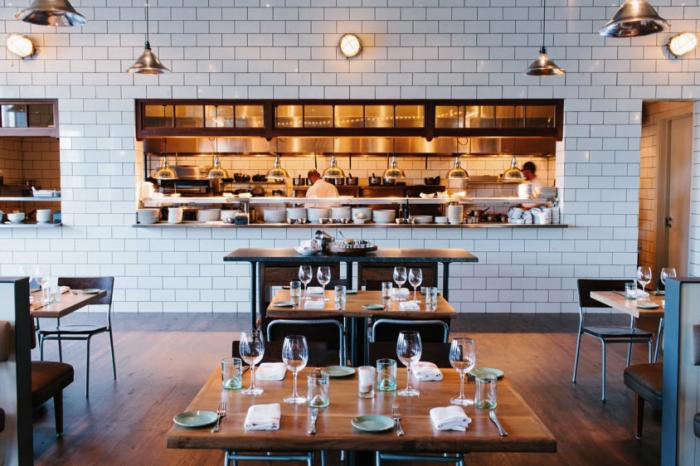 above key design features include subway tiled walls forged metal fixtures and repurposed wood elements like the floor to ceiling windows separated by