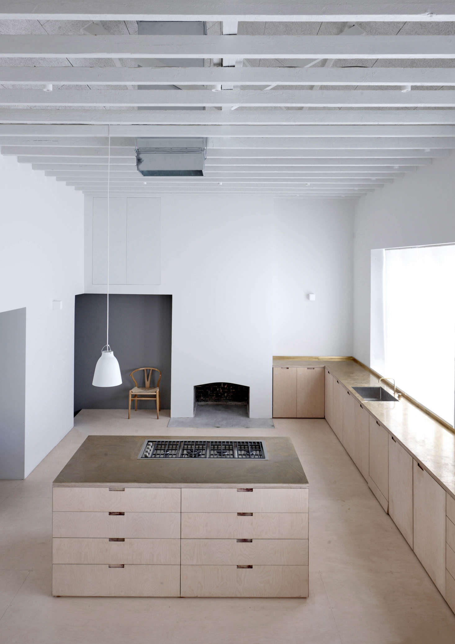 Viewed from the upstairs bedroom, the kitchen is “almost church-like in scale and arrangement” says McLaren, noting that the materials have been “left in their natural state—’as found’—and, together with the pleasing rhythms of the original building, combine to make a building of conceptual simplicity and spatial purity.”