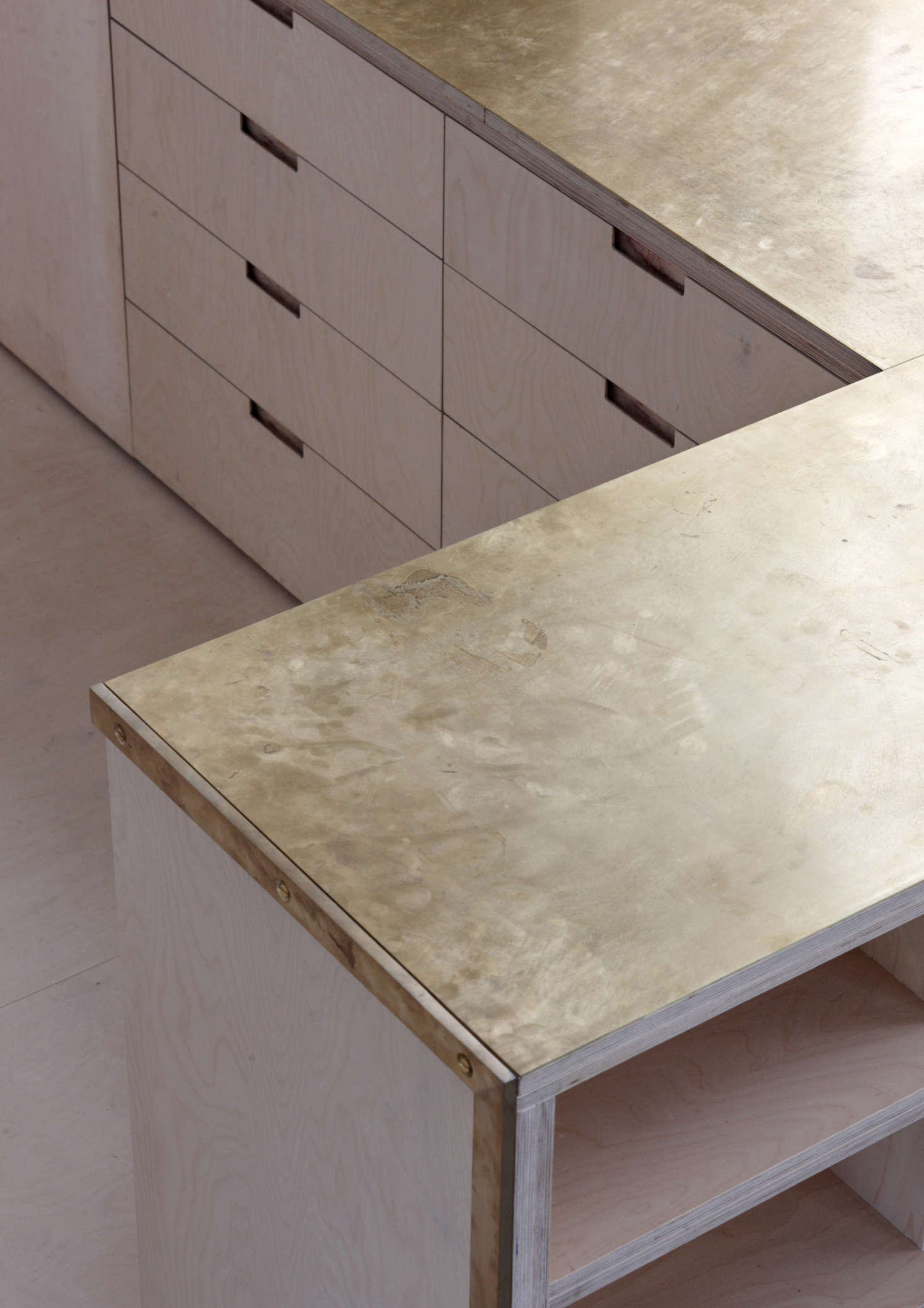 The counters (two layers of 18mm birch ply bonded with two millimeters of brass: total thickness 38 millimeters) are unlacquered and intended to gather fingerprints and patina over time. All millwork was designed by McLaren Excell and fabricated locally.
