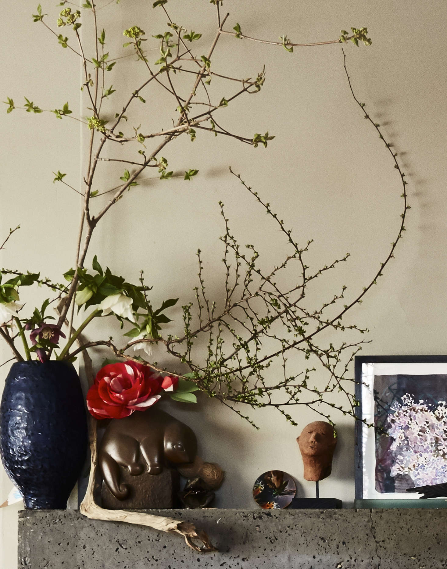 It took sixty 80-pound bags of concrete to create the mantel. (“It’s framed in white melamine and we did two pours.”) That’s one of Livia’s red paper camellias mixed in with the fresh greenery.