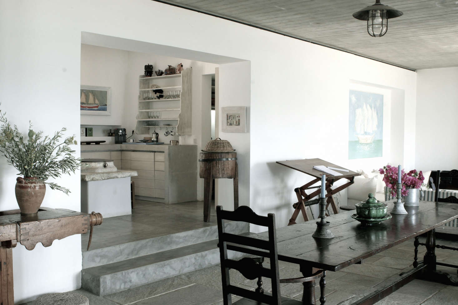 The dining table and chairs are early-19th-century French “monastery style,” and the sideboard is an old carpenter’s bench. Photograph by Costas Picadas, courtesy of Zoumboulakis Architects.
