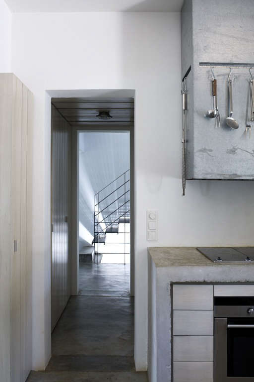 The kitchen opens to a utility room with floor-to-ceiling slatted cupboards and a refrigerator—mere feet from the stove but out of sight. (There’s also a dishwasher concealed to the right of the sink.)