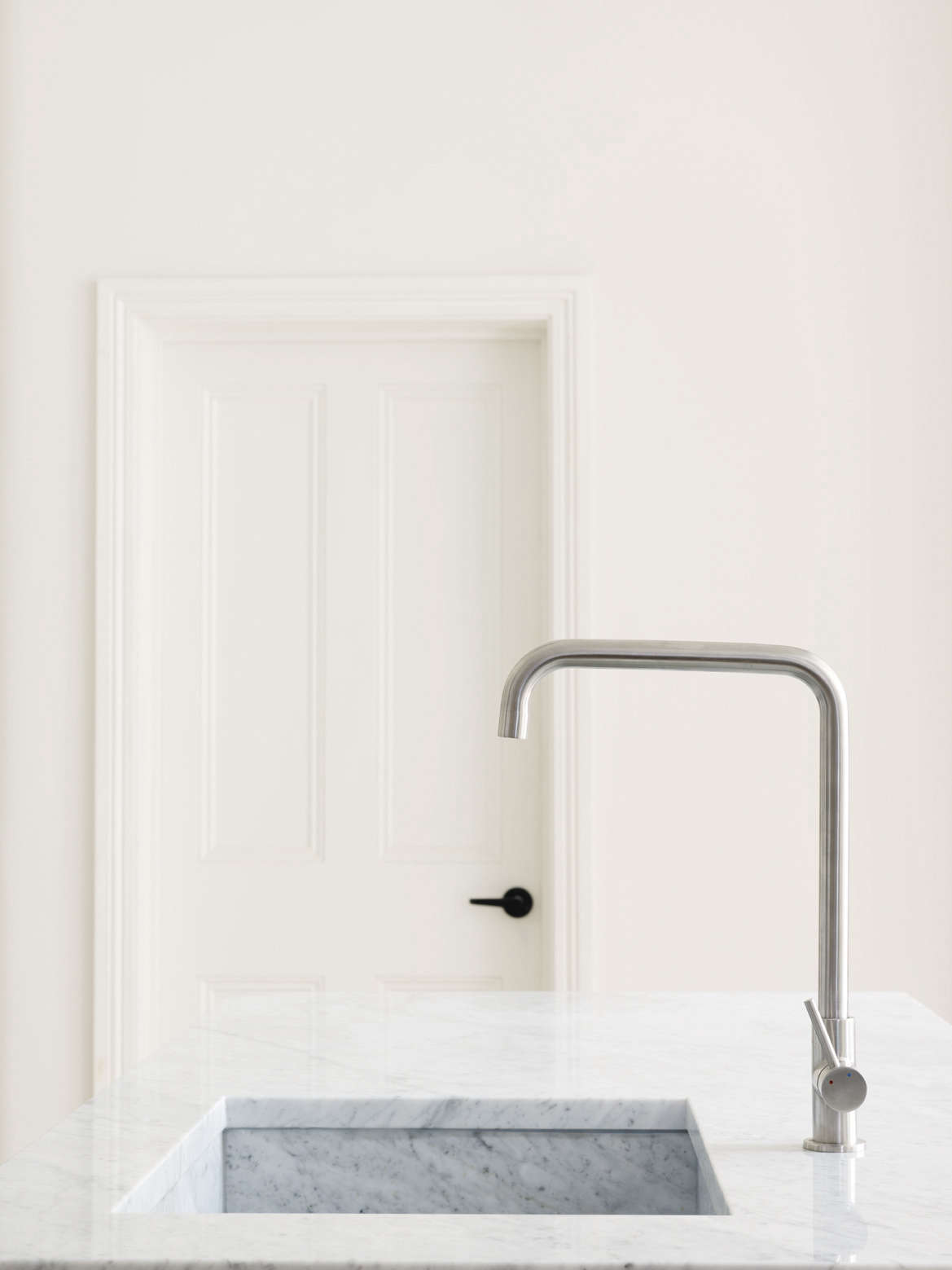 White marble counters and a marble under-mount sink in Kitchen of the Week: A Simple System from Studio MacLean in London.
