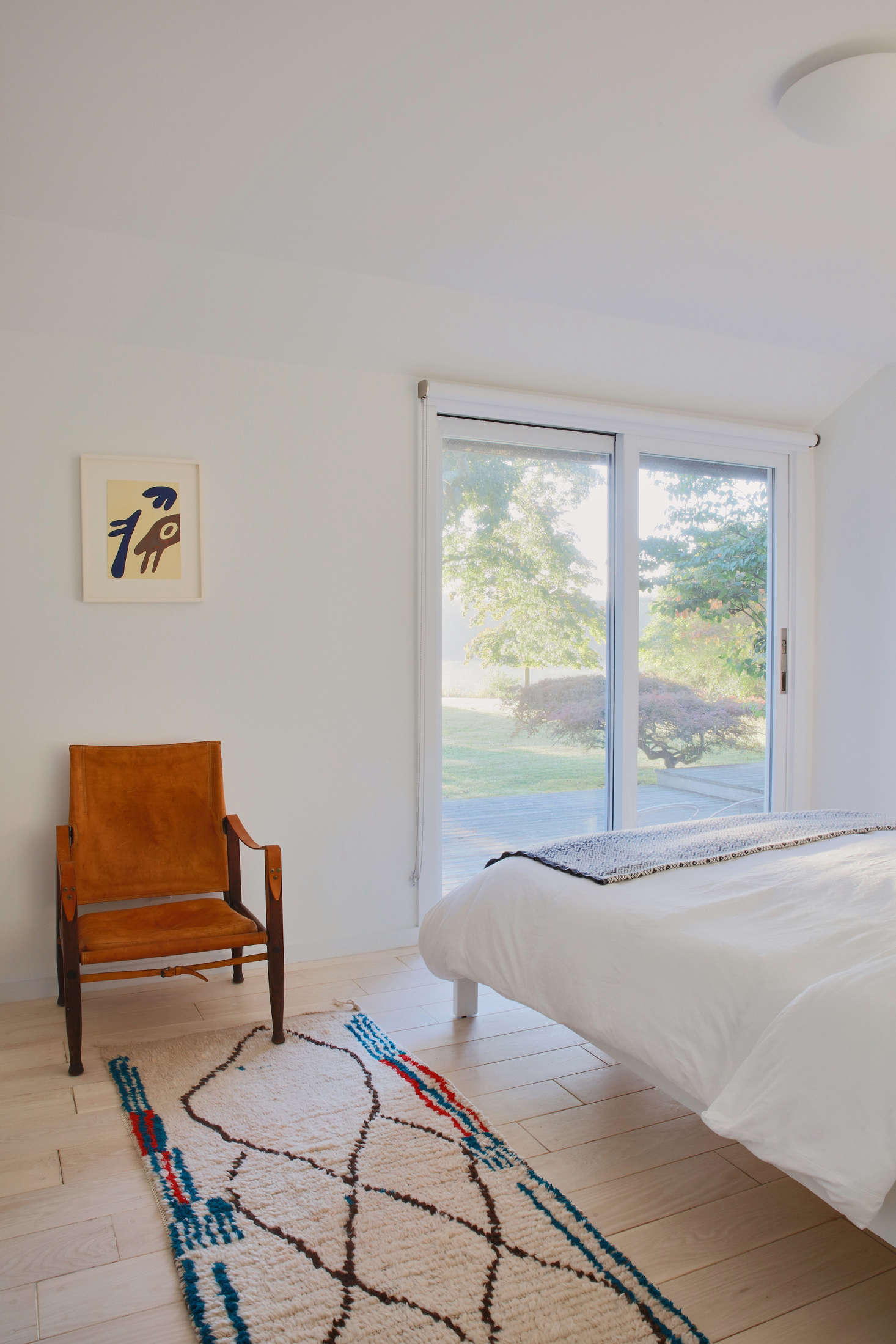 In another guest bedroom, a leather safari chair by Kaare Klint from Pamono and a Moroccan rug from Larusi in London (“the best source for Moroccan rugs in London,” Jones says).