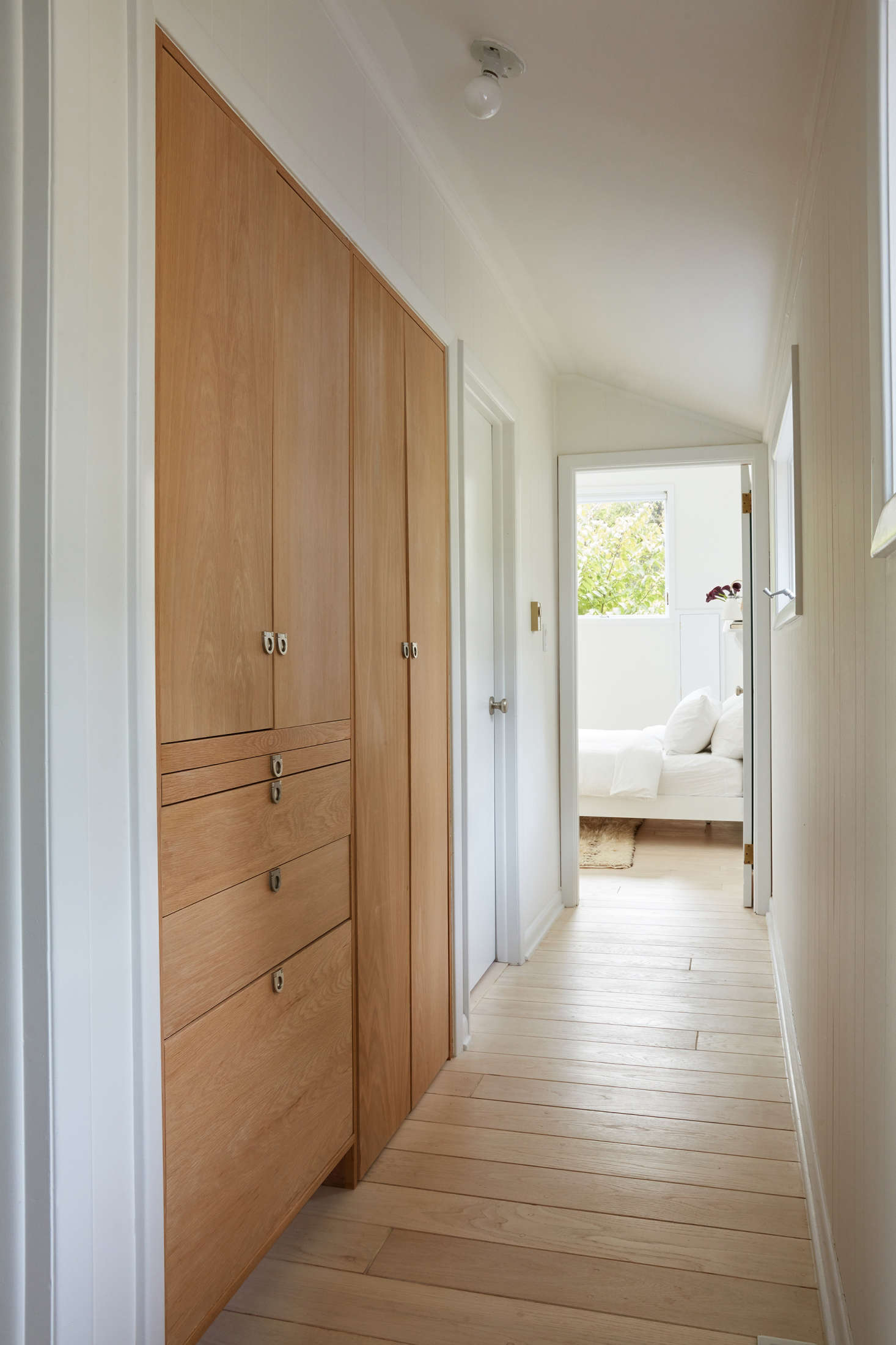 “We installed a custom laundry cabinet in the hallway (inspired by Julie Carlson’s!),” says Jones. Wooden doors conceal a stacked washer and dryer; the drawers keep linens and cleaning supplies out of sight. The Sugatsune satin nickel drawer pulls are from Hardware Hut.