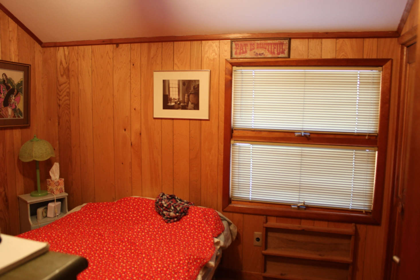 A guest bedroom was covered in dark wood paneling.