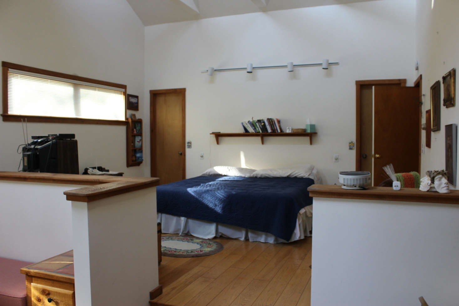 The master bedroom had small windows and a half-wall separating it from the sunken lounge.