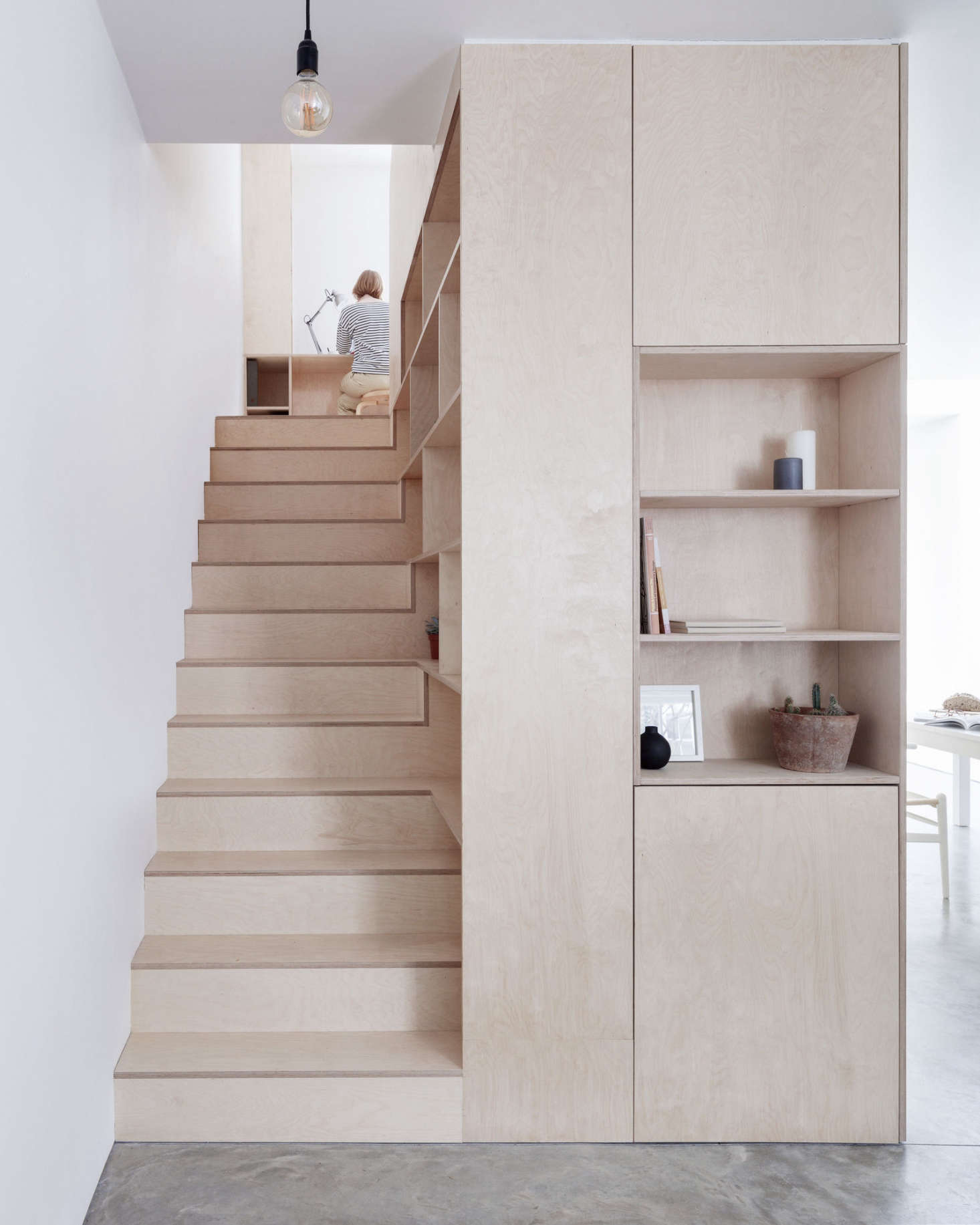 Plywood stairs (and built-in shelving) in A London Townhouse Designed to Catch the Light. Photograph by Rory Gardiner.