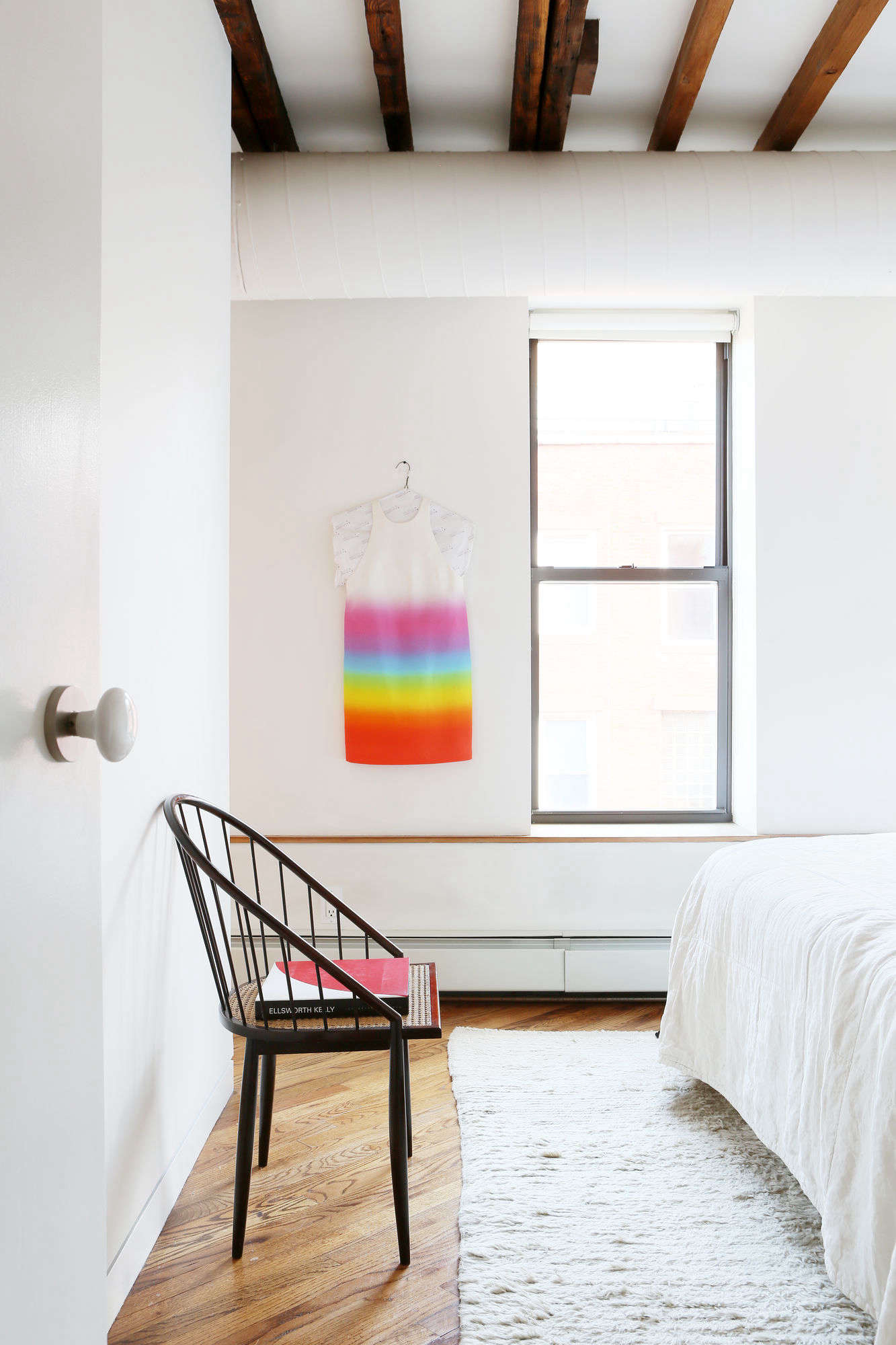 The all-white bedroom gets a burst of color with one of Javitch