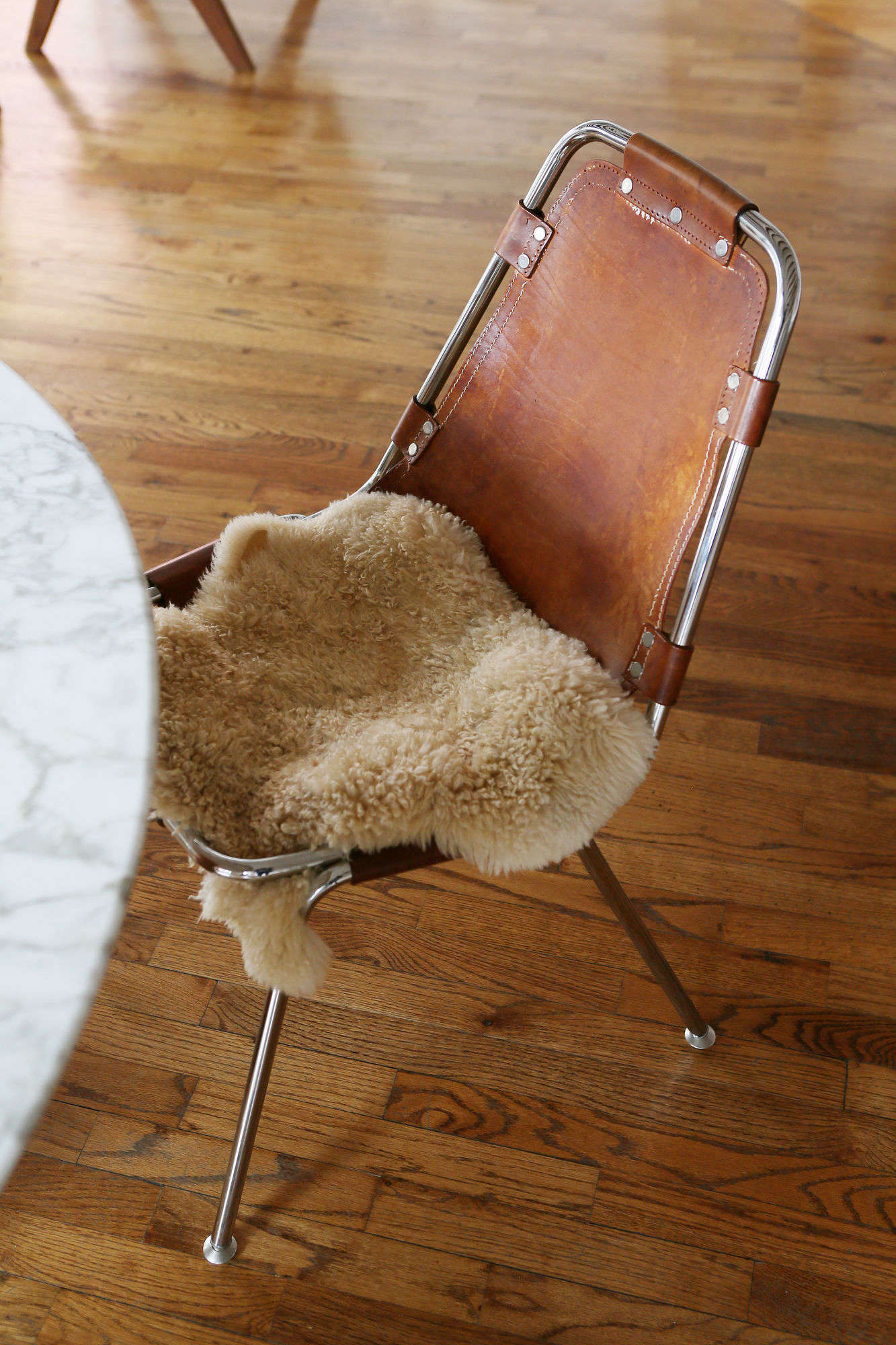 Leather sling dining chairs with swatches of fur add texture.