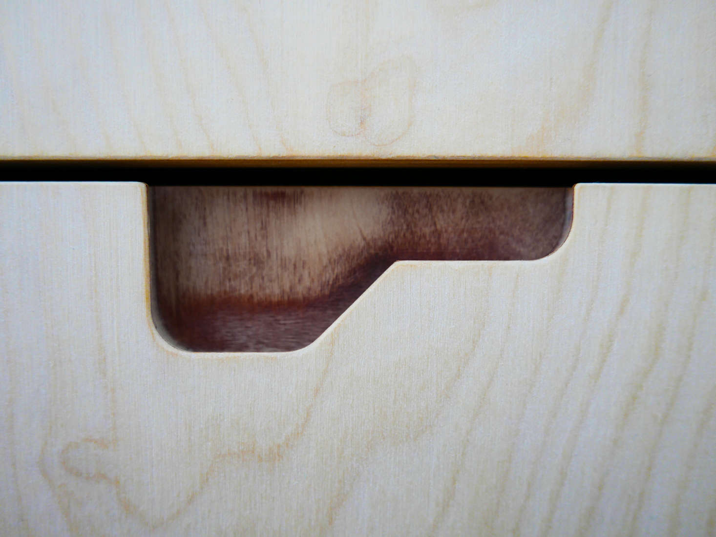 A detail of the cutout, with partially-milled plywood that exposes a darker ply inside.