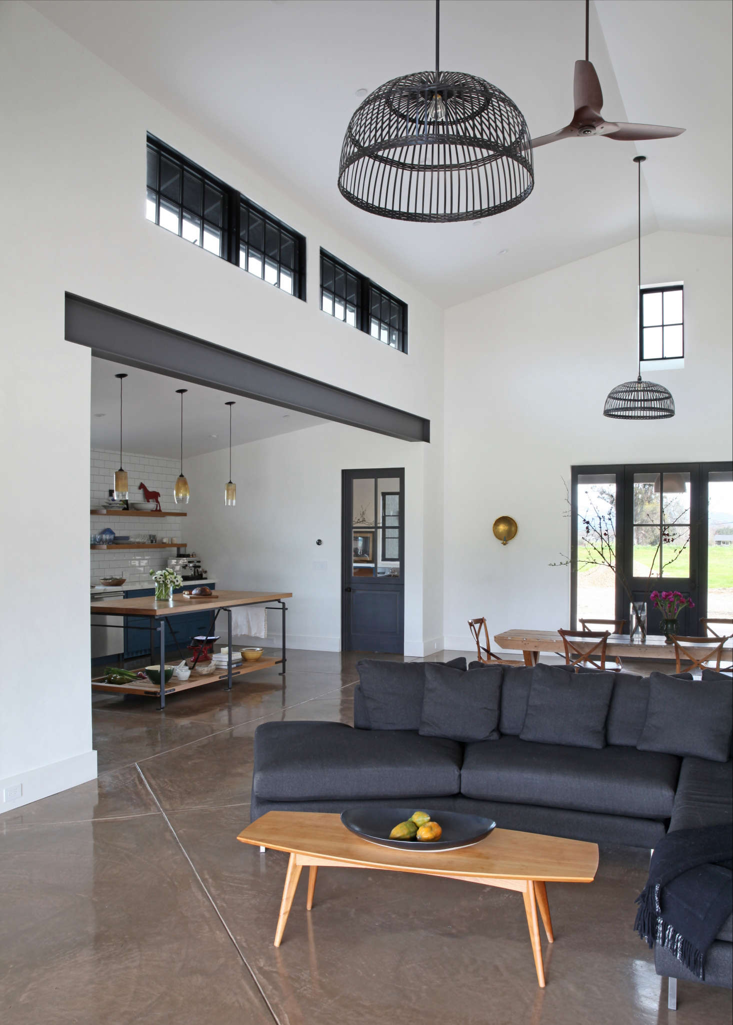 The two black basketweave pendant lights above the living and dining are from Ikea, modified with the power cord installed inside a down rod to minimize movement. The coffee table is from Room & Board.