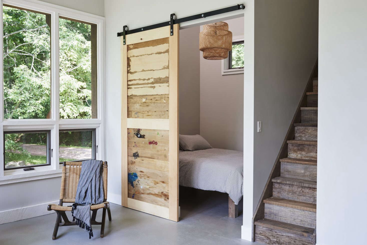 A sliding barn door is made of salvaged wood from the artist’s cabinet drawers (paint splotches included).