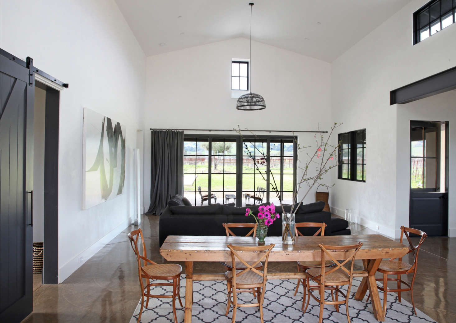 The couple surrounded their antique dining table with chairs by Thonet. Throughout the house, floors are tinted concrete with radiant underfloor heating and a high-gloss polyurethane finish.