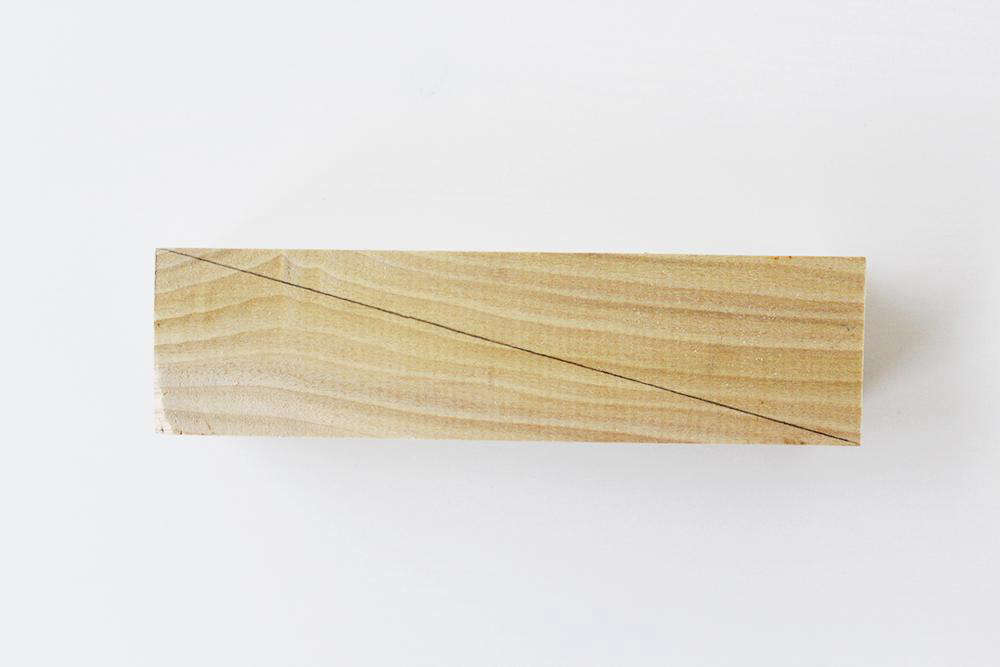 Step 1: Mark a diagonal line across the length of your wood, and saw in half. “If you start with a longer piece of wood, it’s easier to mark the six-and-a-half-inch length and saw the diagonal line,” advises Anna.
