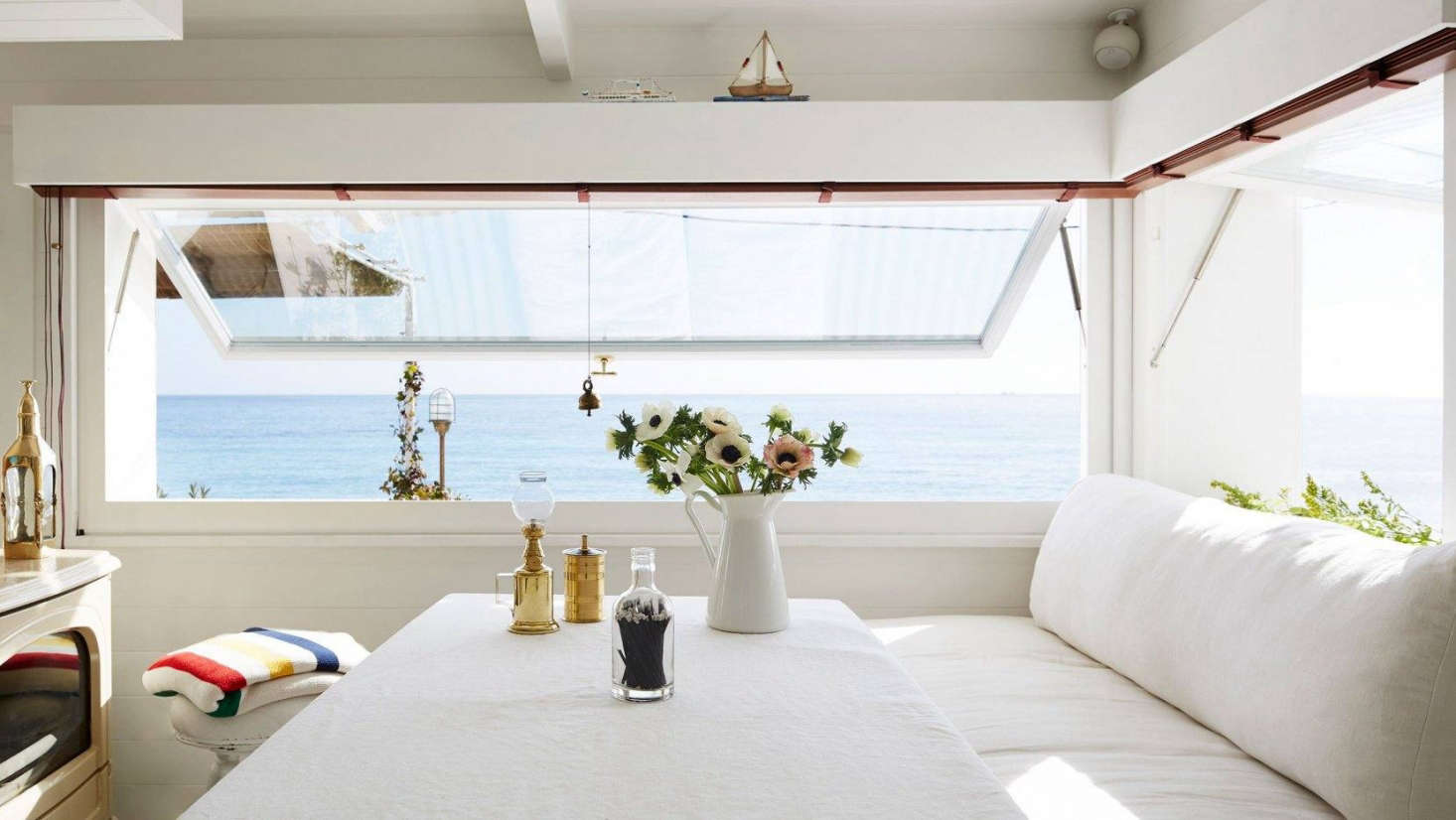 The dining area with built-in banquette and awning windows that offer unbeatable views of the Mediterranean.