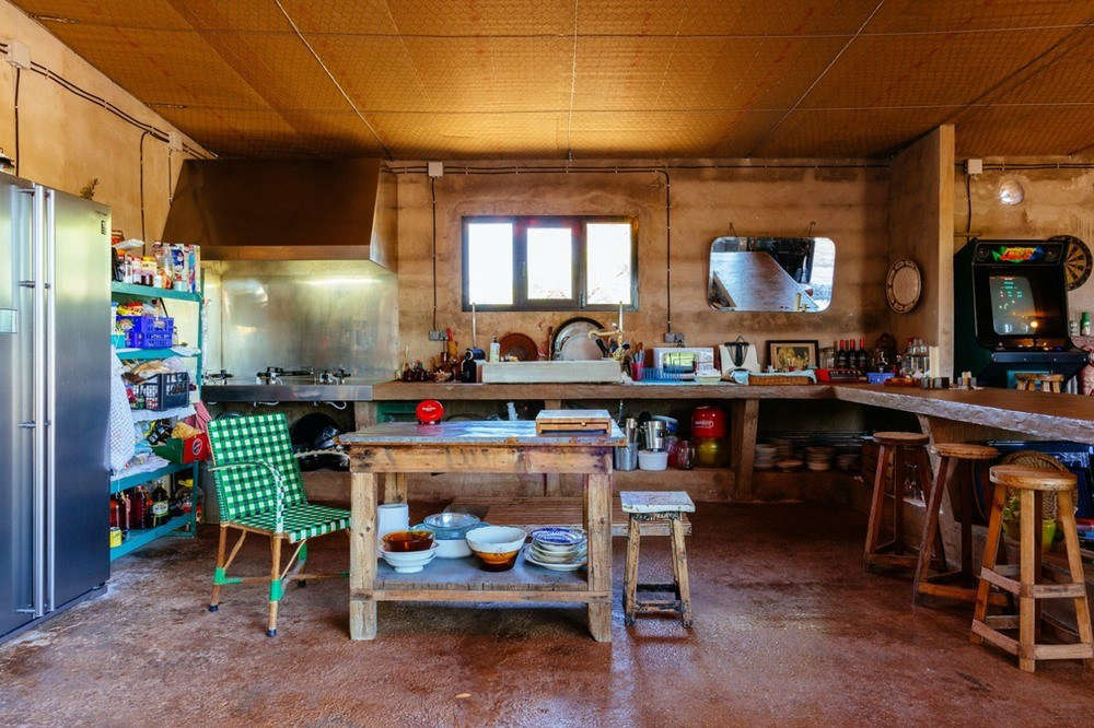 The designers converted an abandoned garden center into a summerhouse. Its rustic kitchen is in what had been a potting shed, with its cement floor and plant table still in place: “We took out four tons of plastic and did a lot of cleaning.”