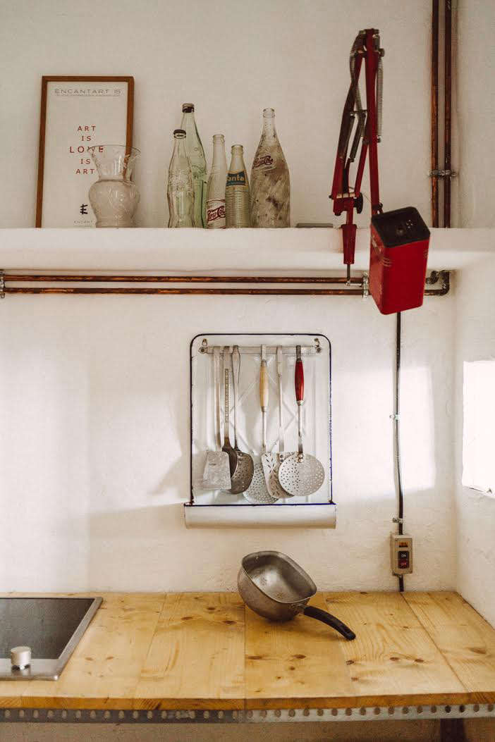 Quintana Partners travel for their finds: the kitchen’s vintage enamelware utensil rack and clamp light came from a flea market in the South of France.