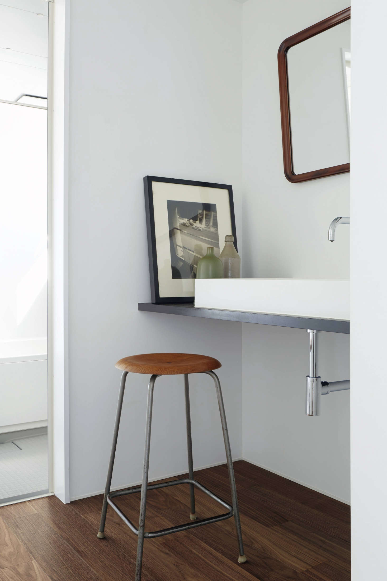 In the family bath, a stained Douglas fir shelf supports a simple sink and serves as a place to prop art. The designers used an affordable off-the-shelf Japanese unit system in the inner bathroom.