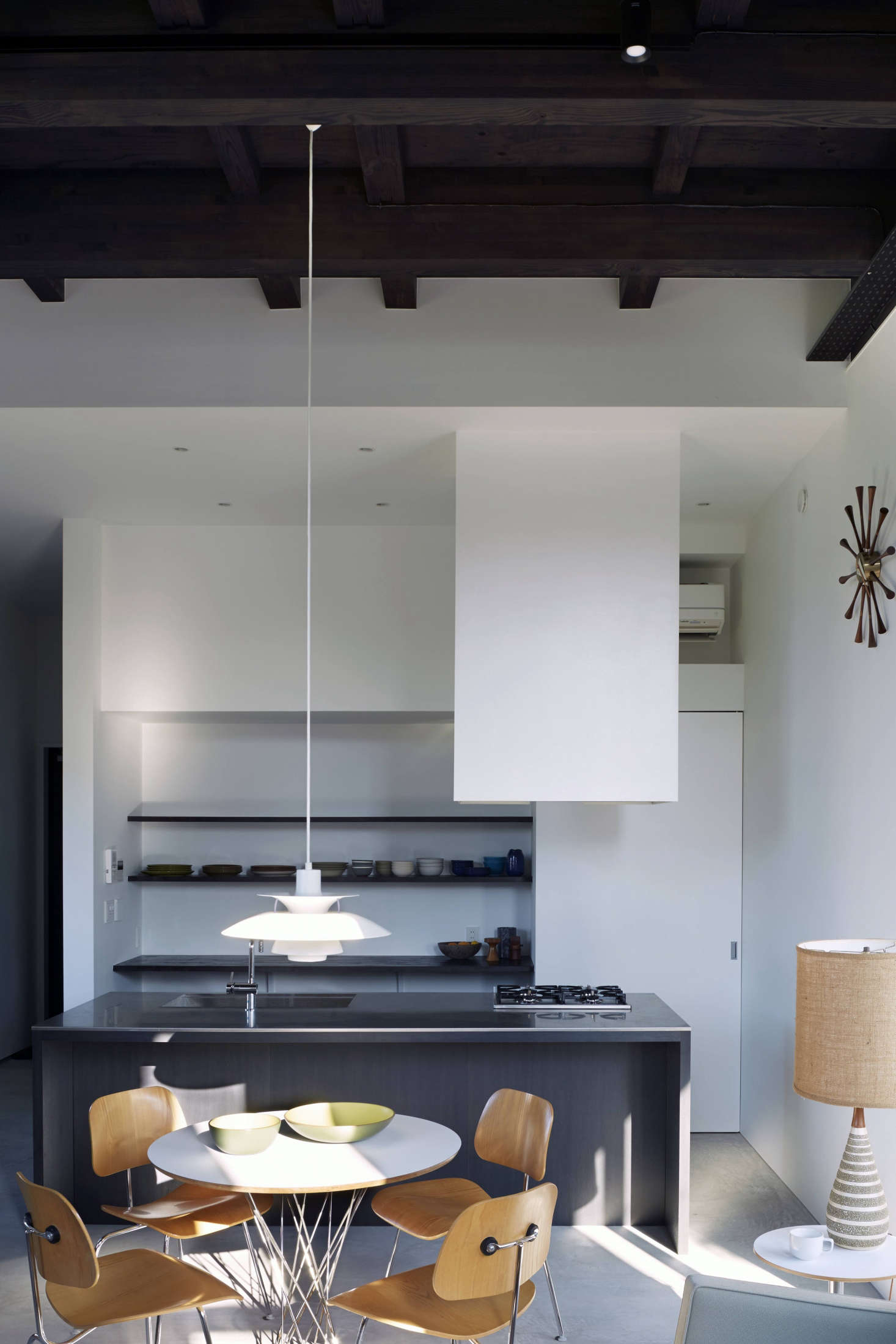 The kitchen is set off by a stainless-steel-topped stained oak island modeled after a Donald Judd piece. It has a four-burner cooktop, the standard size in Japan, and a Sheetrock-encased hood that extends from the ceiling: 