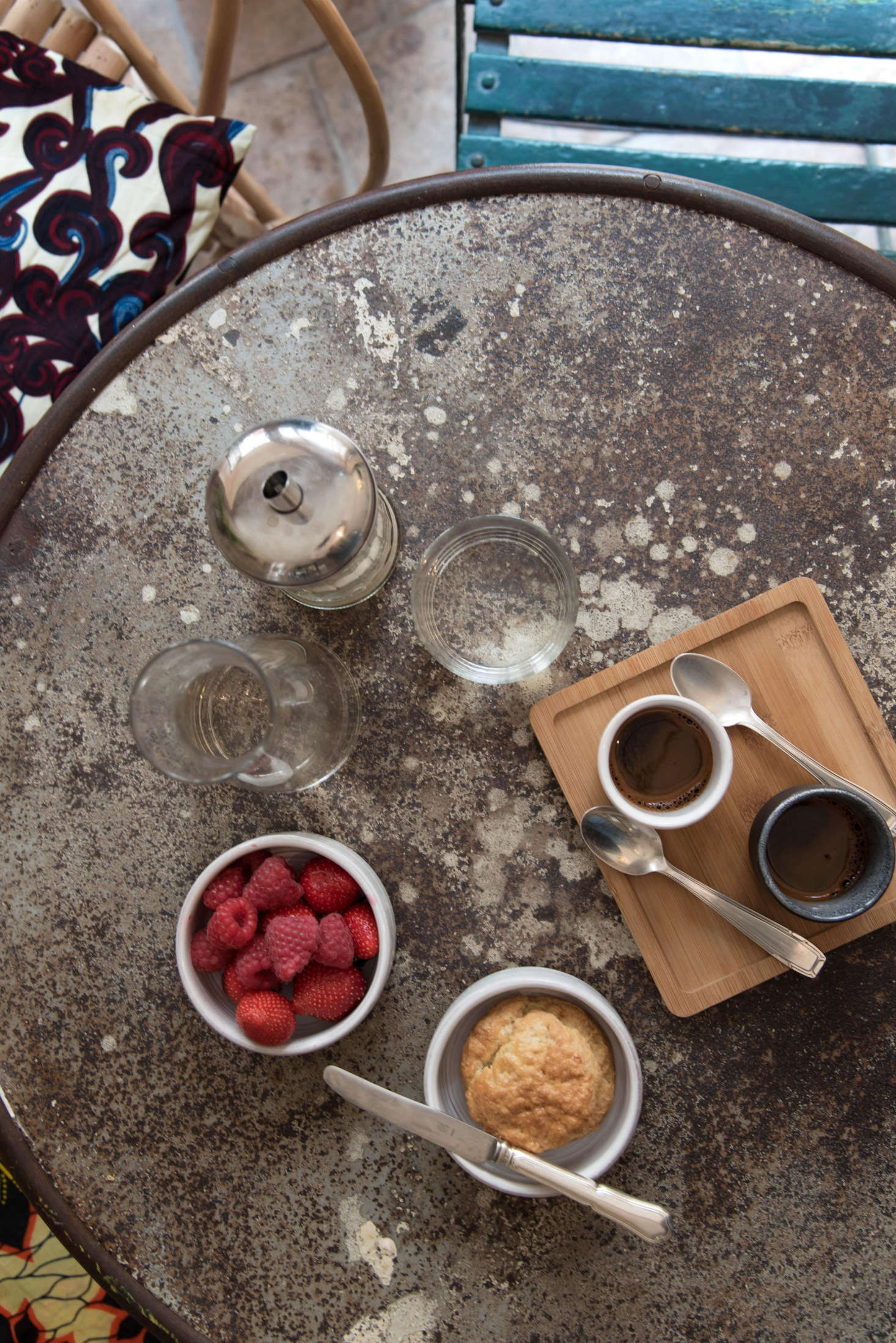 On a vintage cafe table, ceramics by an Italian artisan living in Belgium mix with Japanese wooden trays and “classical glassware for French bistros.” Simple shapes keep it cohesive.