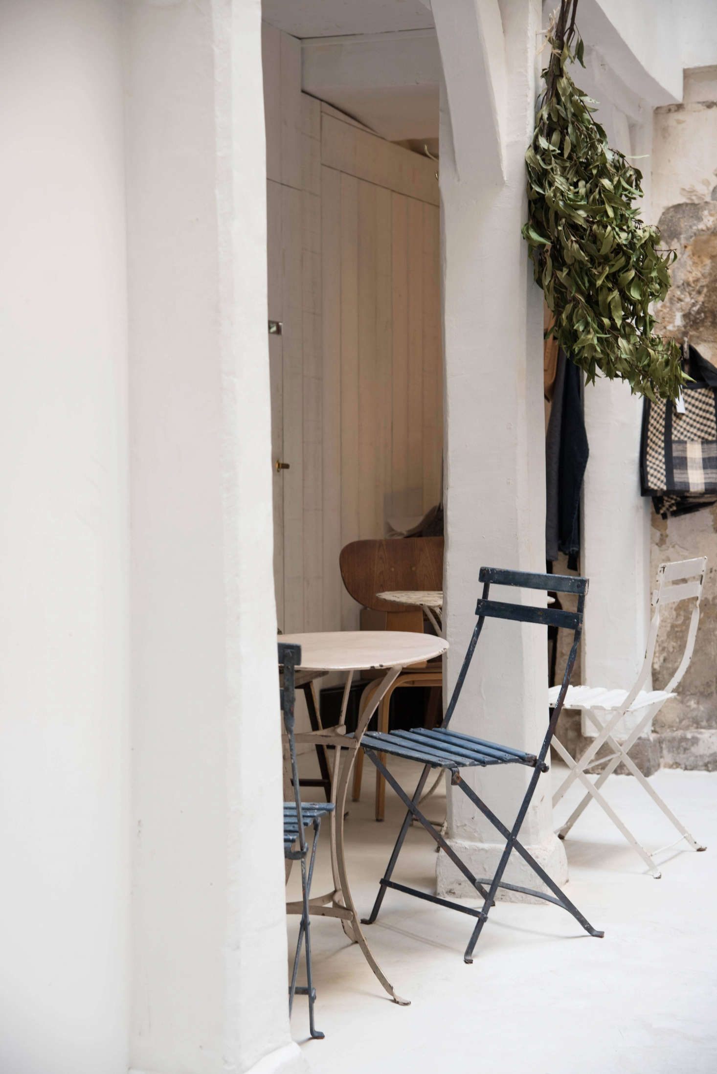 De Villeneuve and Champsaur took cues from the feel of each section within the “atypical long space.” Here, a high-ceilinged area was left bright and open, beams and archways become niches for dining, and vintage cafe furniture in muted hues doesn’t compete with room’s light and simple lines.