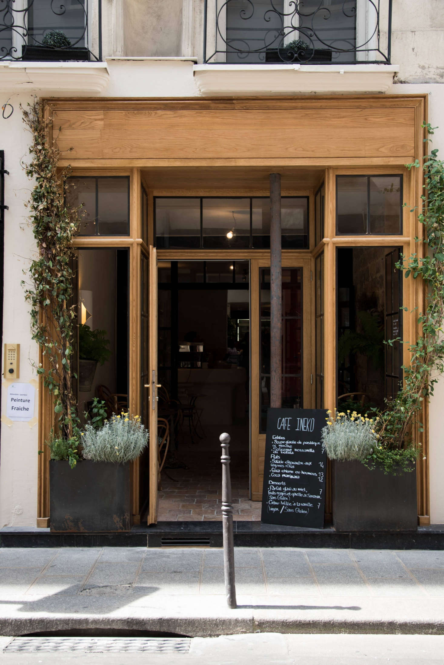 Consider curb appeal: To invite passerby into Café Ineko, de Villeneuve and Champsaur transformed the facade with new wood trim. “The building is from the 17th century and protected,” de Villeneuve says, so after getting special authorization from the city, they tread carefully to upgrade the exterior (and the interiors) with respect to its history. Potted plants, custom steel-frame doors and windows, and trailing vines add to the charm.