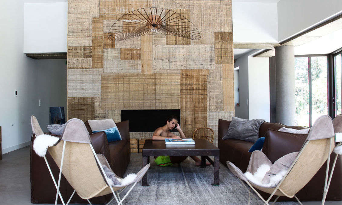 The ground floor is an open-flow, door-free series of living and dining rooms. Prudent created a patchwork hearth using woven bamboo wallpapers, a stylish reference to the house