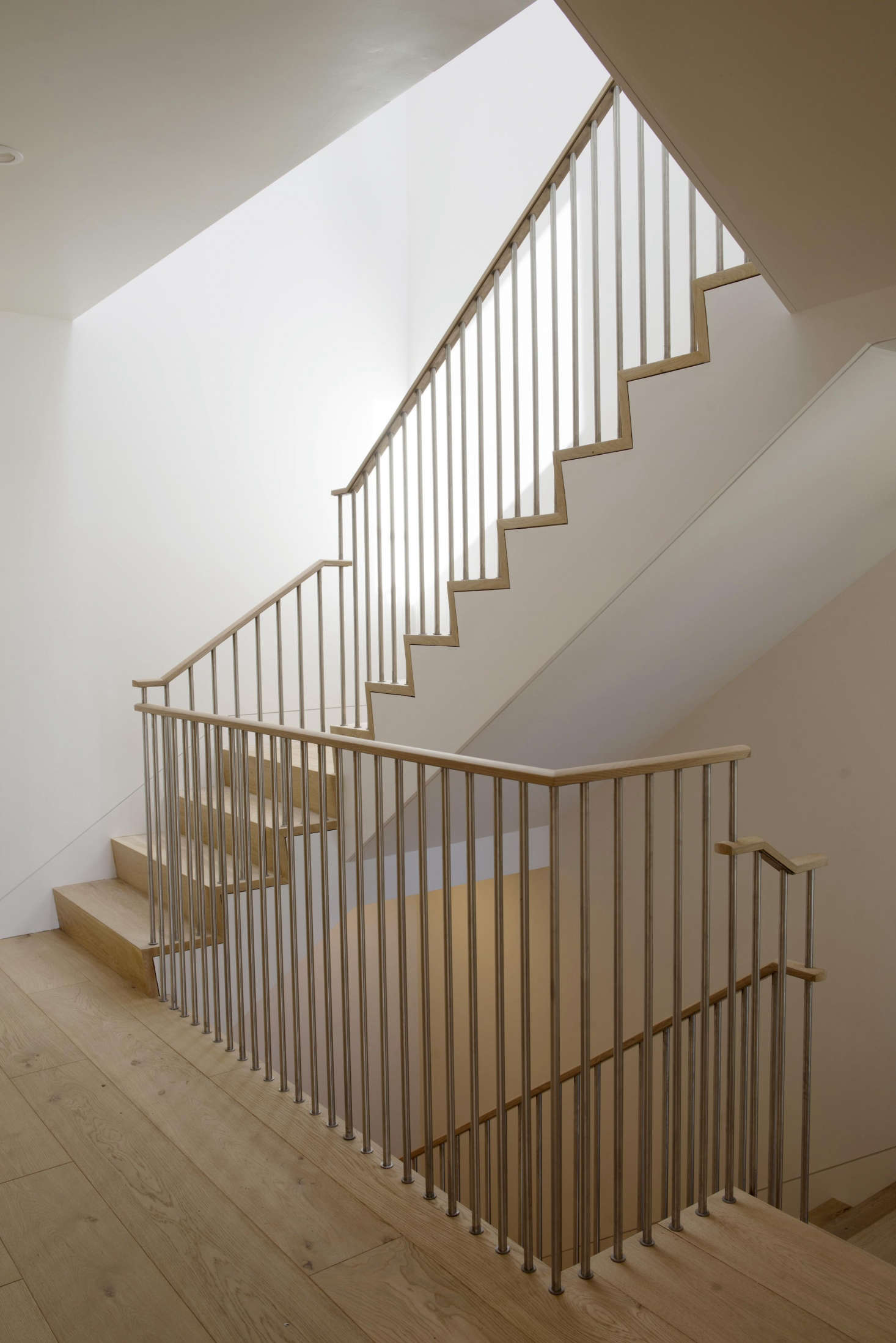 A steel and oak stairway connects the three floors in each unit.