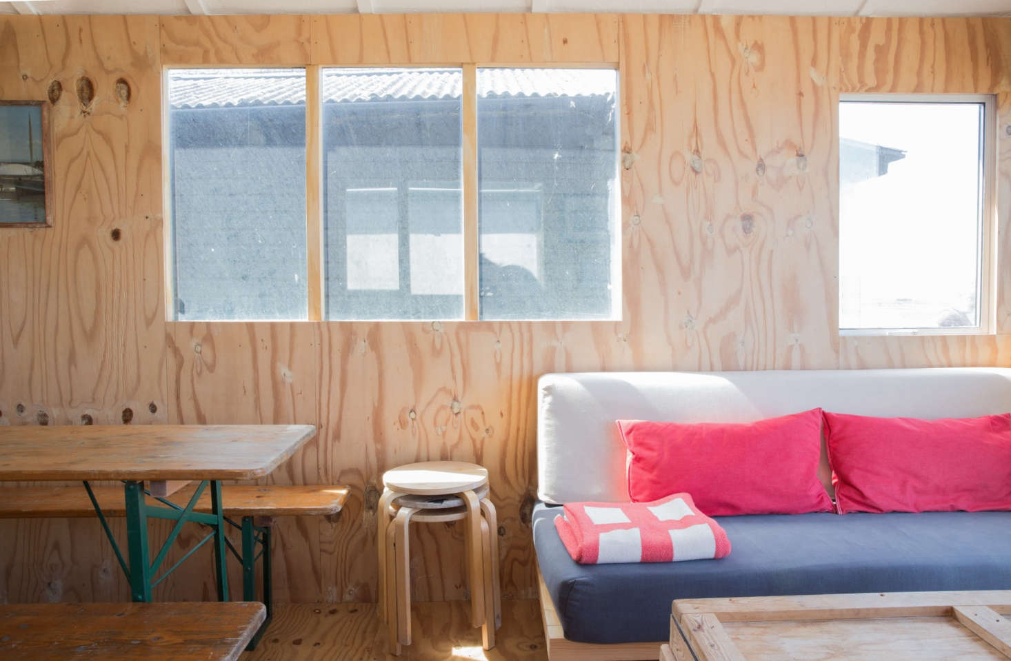 The sofa, which serves as an extra bed, is a homemade wooden platform—