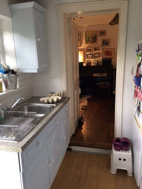 Tucked into a side addition of the house, the galley kitchen—installed decades ago as a replacement for the original kitchen—is now used as a utility room.