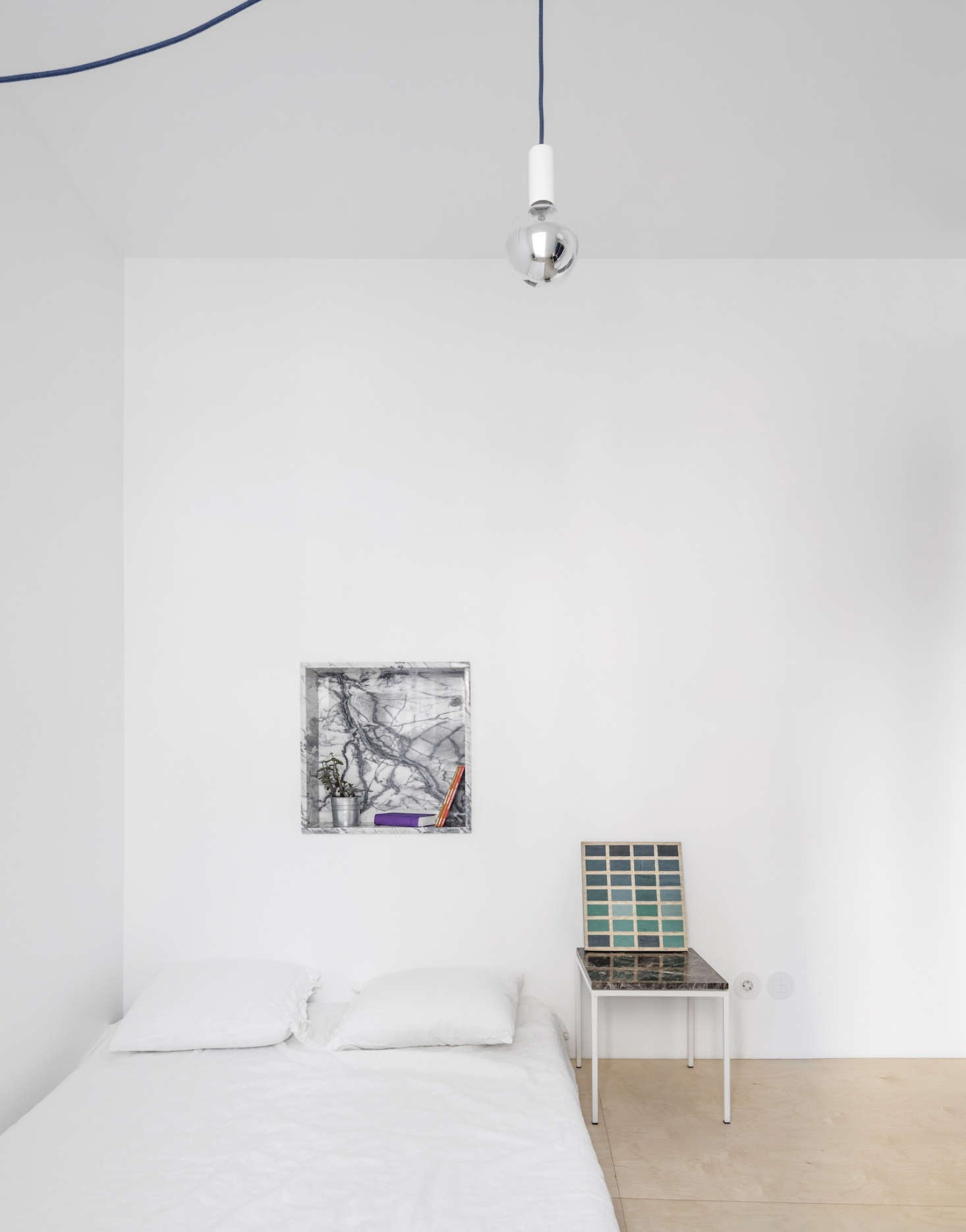 A small wall niche makes an impact when lined in small marble pieces; photograph from A Narrow but Glamorous Marble-Clad Apartment in Lisbon.