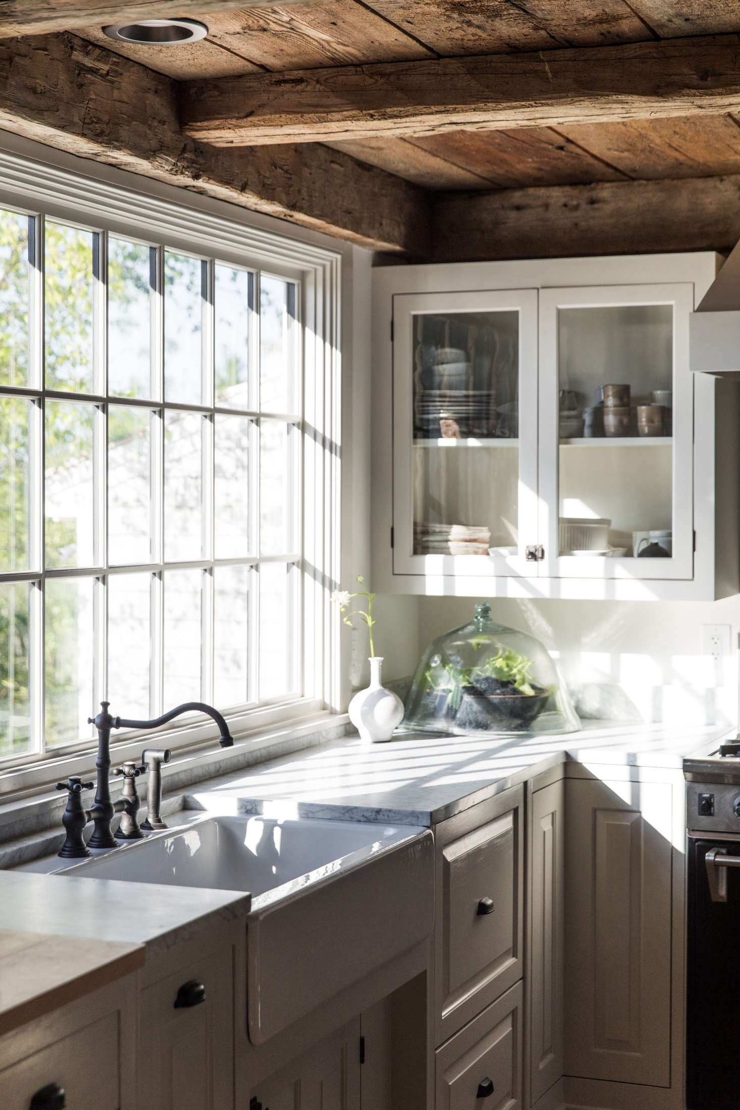 In the kitchen, light filters in through the original paned windows.