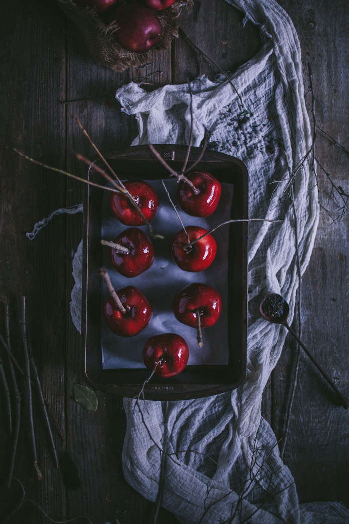 Candied apples are made creepier with dead branches as handles.