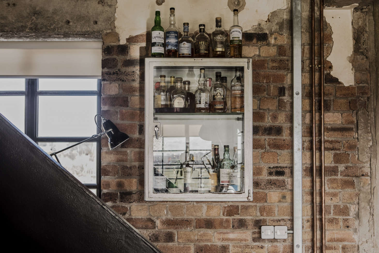 A vintage medicine cabinet serves as a liquor cupboard.